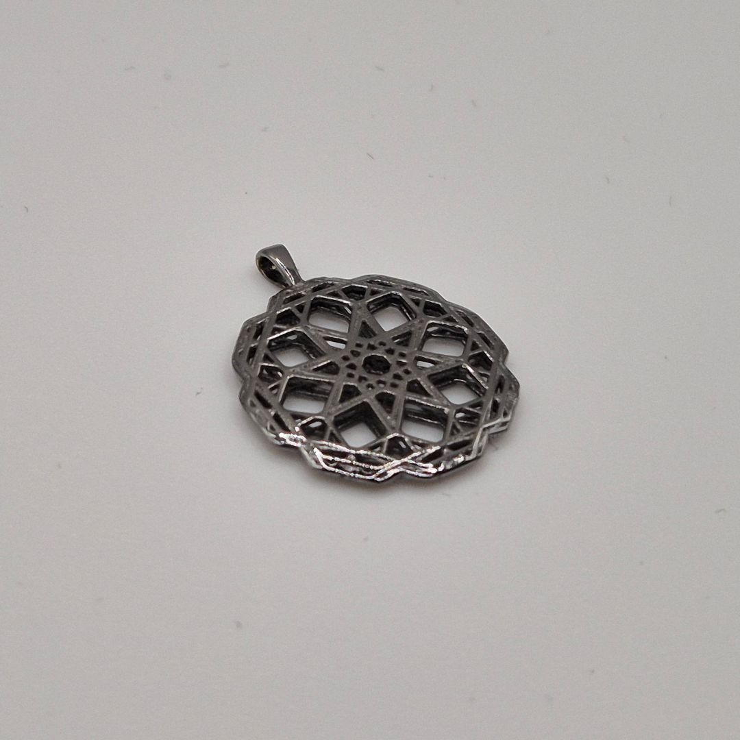 Flat round pendant with intricate pattern in black rhodium plated brass