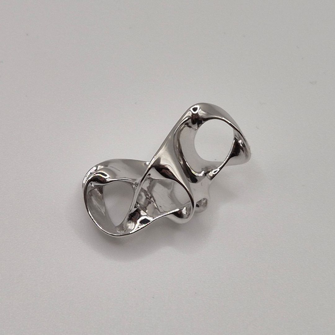 Showcase of a Highly reflective, chrome-plated brass casting with interlocking ring design, showcasing the sleek, mirror-like finish of 0.5 micron electroplating.